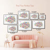 Colorful Paris illustrated map poster size guide displaying seven framed artwork sizes above a blush pink sofa.