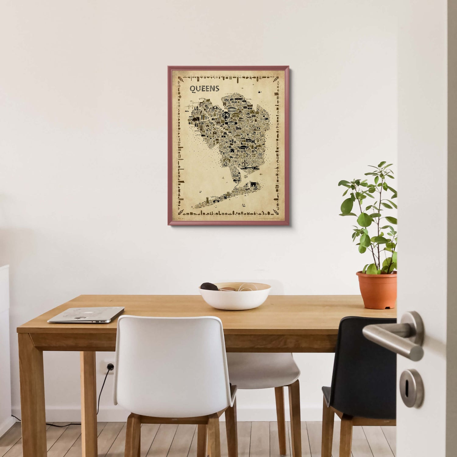 Iconic Queens Poster – Antique Edition in a dark burgundy wood frame, styled in a dining room with wood table, laptop, ceramic bowl, houseplant, and modern chairs. Classic NYC borough map print for home décor.