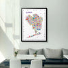 Framed Alfalfa New York Queens illustrated map poster hanging on a light gray wall above a modern dining nook with neutral seating and minimalist decor.

