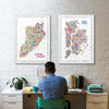 Person sitting at a desk with colorful Staten Island and New York maps on the wall.