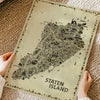 Hands holding the Iconic Staten Island Antique Edition printed on premium matte paper, highlighting the artwork's texture, quality and detailed vintage illustrated map.