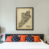 Black-framed Staten Island Antique Edition hanging above a bed, adding timeless vintage character and New York-inspired décor to a modern bedroom.