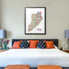 Colorful map of Staten Island on a wall above a bed with decorative pillows.