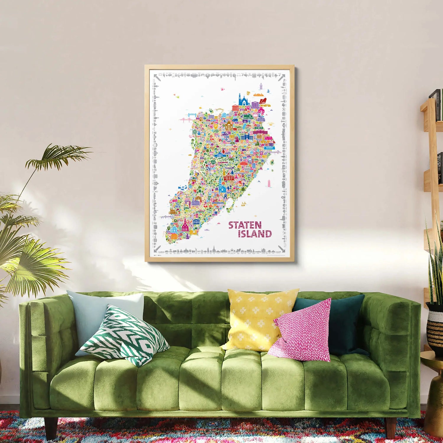 Colorful Staten Island map in a frame above a green sofa with decorative pillows.