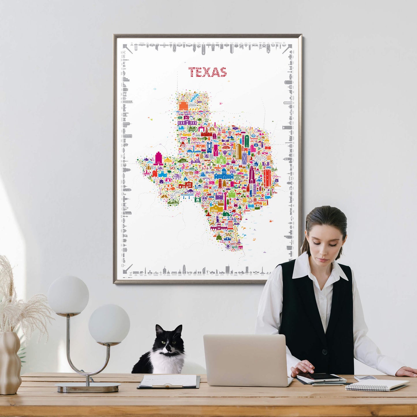 Woman working at a desk with a colorful Texas map poster on the wall.