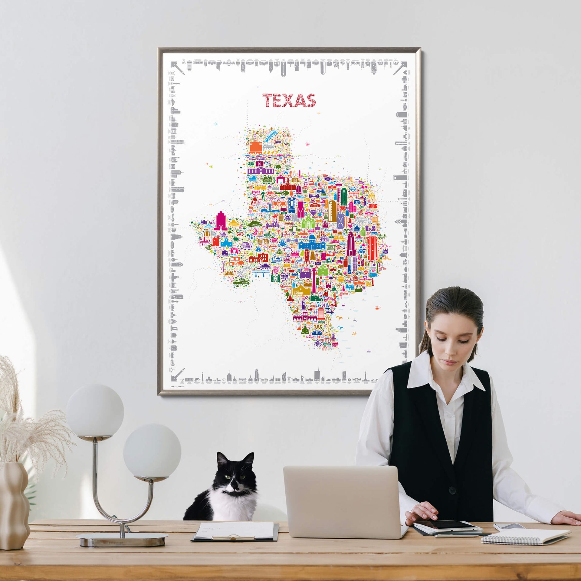 Woman working at a desk with a colorful Texas map poster on the wall.