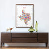 Colorful Texas map poster on a wall above a wooden console table with decorative items.