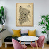 The Bronx Antique illustrated map poster in a natural wood frame hanging above a cozy dining nook with pink chairs, mustard yellow pillows, a black bench, round white table, cactus, and green plants.