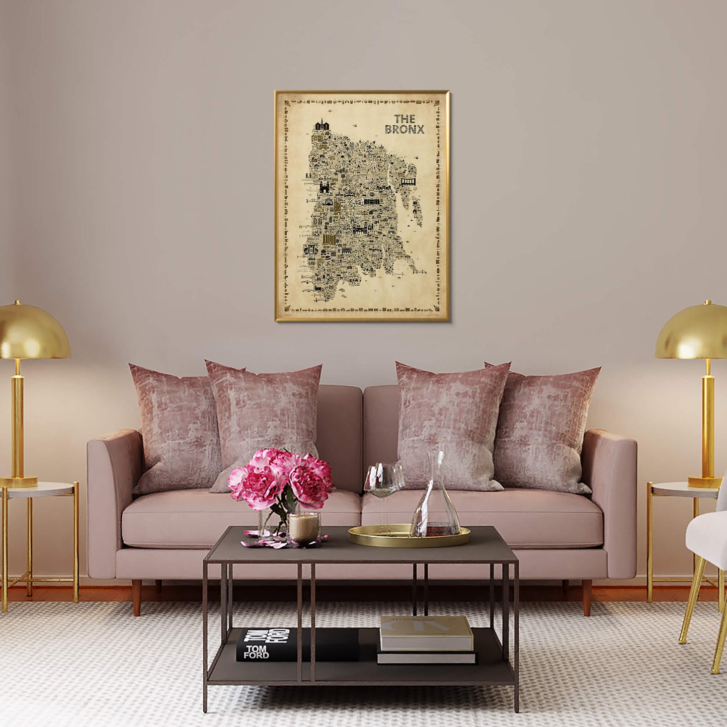 The Bronx Antique illustrated map poster in a gold-toned frame hanging above a blush sofa with velvet pillows, brass lamps, flowers, and elegant contemporary living room decor.