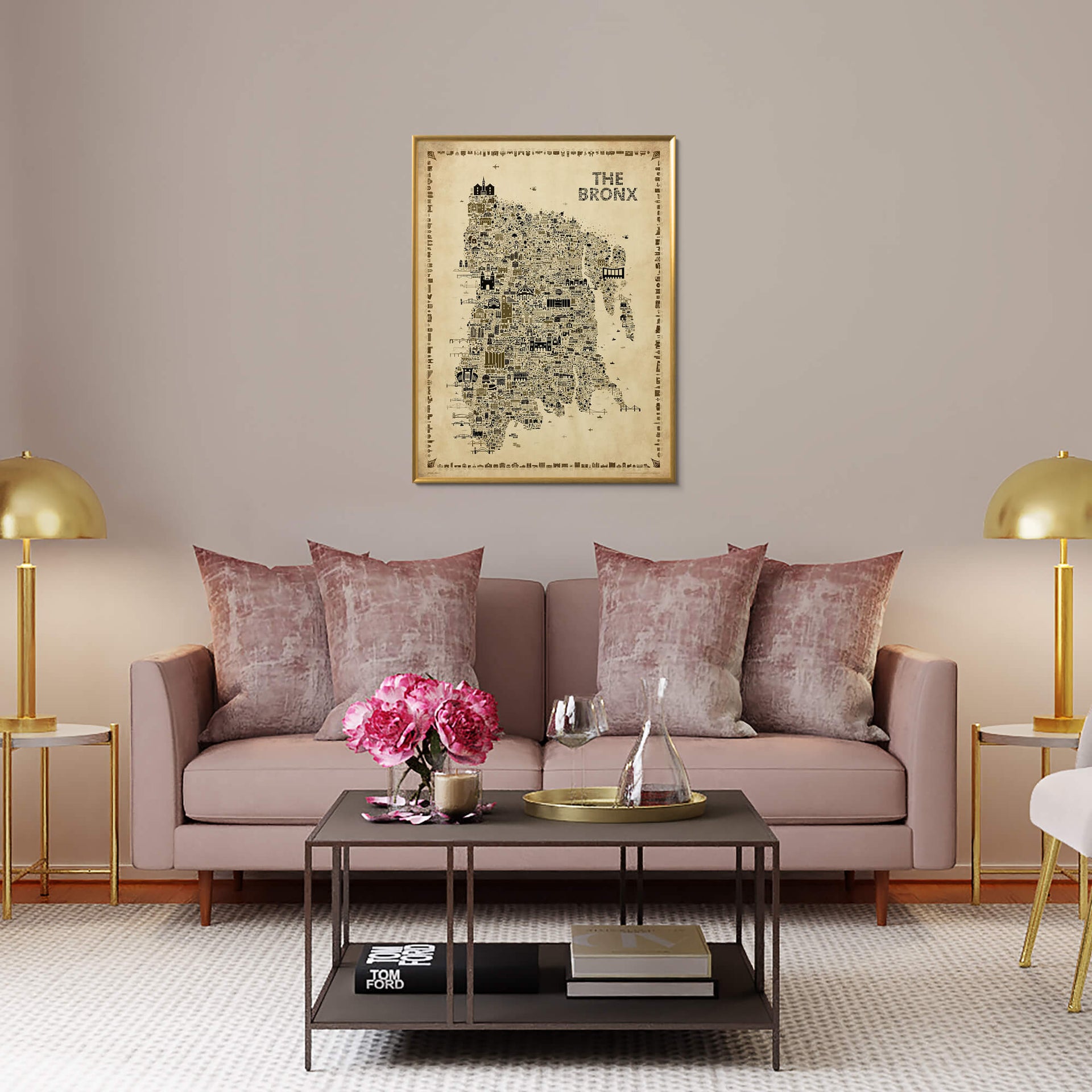 The Bronx Antique illustrated map poster in a gold-toned frame hanging above a blush sofa with velvet pillows, brass lamps, flowers, and elegant contemporary living room decor.
