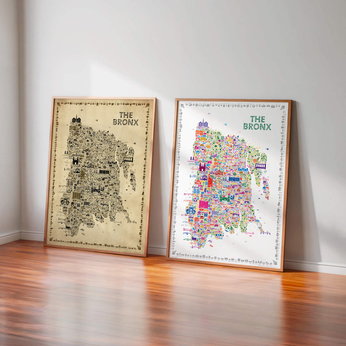 The Bronx illustrated map posters in Antique and Colorful editions displayed side by side in natural wood frames, leaning against a light wall on a polished wood floor.